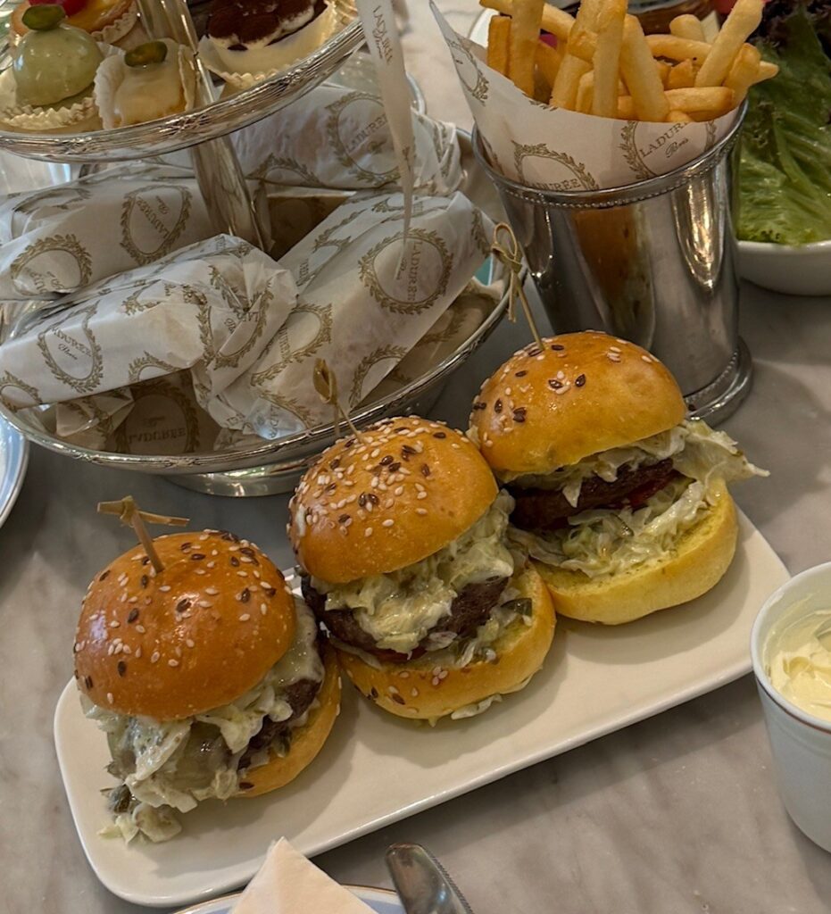 Three juicy beef sliders with melted cheese, served with golden fries and fresh salad at Ladurée Dubai Hills Mall