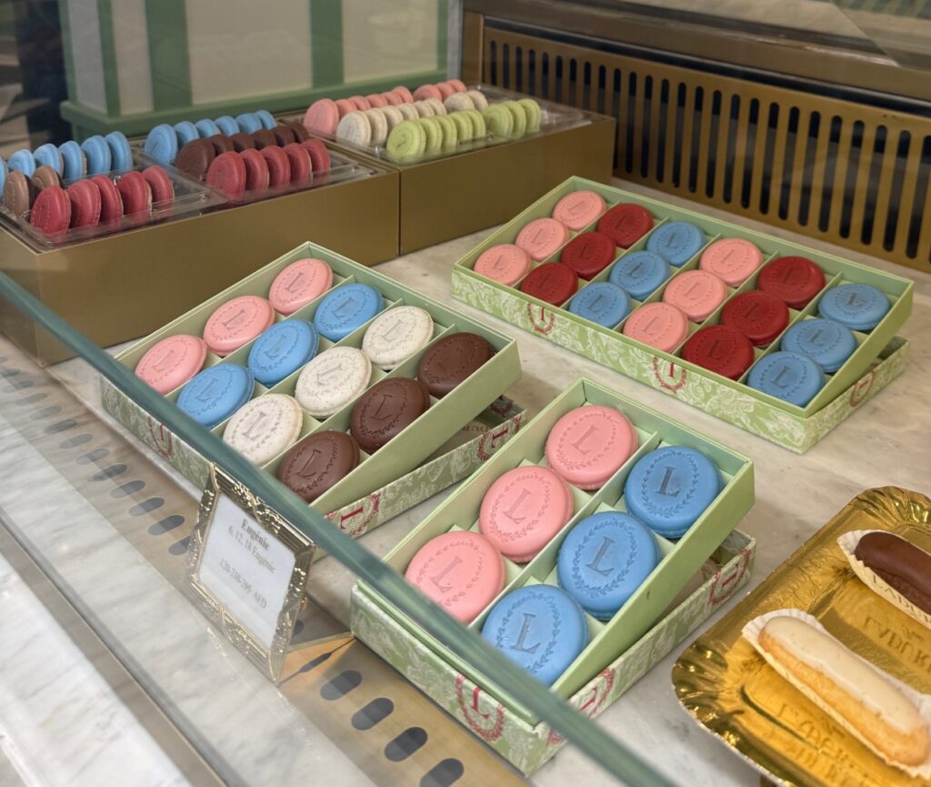 Display counter at Ladurée Dubai Hills Mall filled with vanilla and rose Eugénies pastries