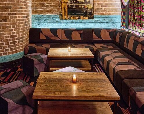 Corner lounge seating at Miss Lily’s Caribbean restaurant in Dubai with a cosy table setup.