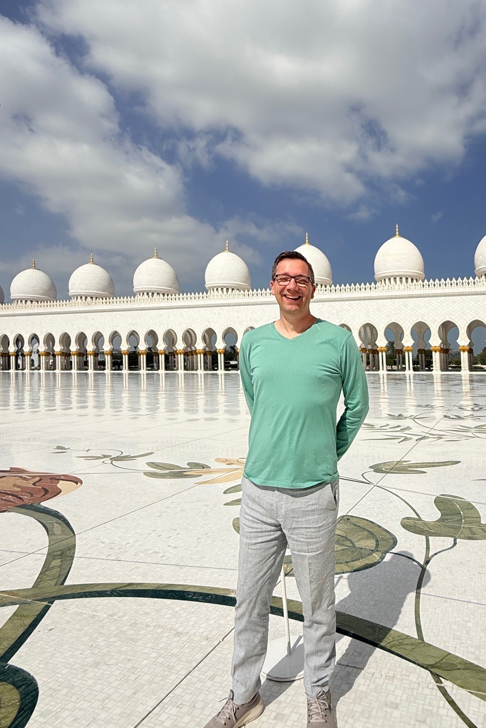 Male visitor wearing appropriate modest clothing at Sheikh Zayed Grand Mosque Abu Dhabi.