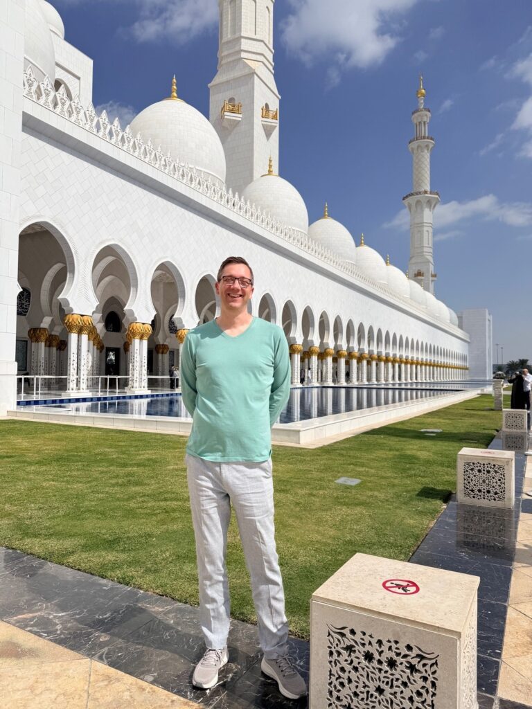 Male visitor wearing appropriate modest clothing at Sheikh Zayed Grand Mosque Abu Dhabi.