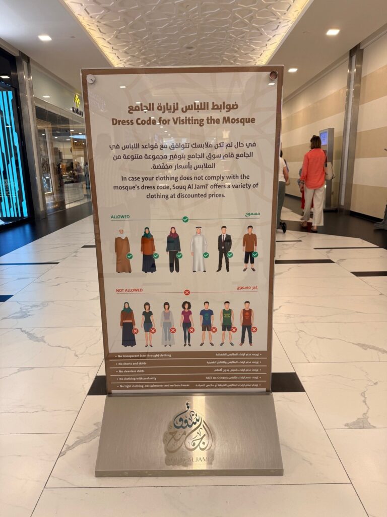 Grand Mosque Abu Dhabi dress code sign showing modest clothing requirements for men and women.